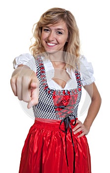 German woman in a traditional bavarian dirndl pointing at camera