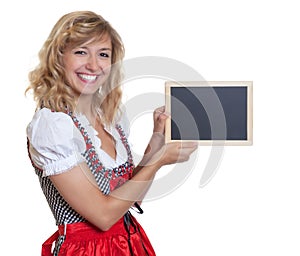 German woman in traditional bavarian dirndl presenting chalk board