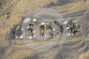 The german word Ostsee - baltic sea made with pebbles in the sand