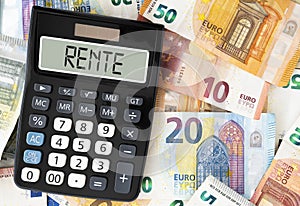 German word RENTE pension on display of pocket calculator against paper money