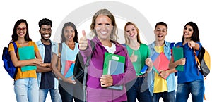 German young adult woman showing thumb up with large group of international students