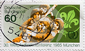 GERMANY - CIRCA 1985 : a postage stamp from Germany, showing  a lily emblem and young boy scouts. World Scout Conference