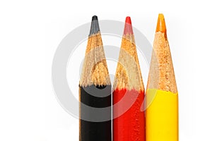 Germany flag colours in coloured pencils in black, red and gold in a closeup photo isolated on white background