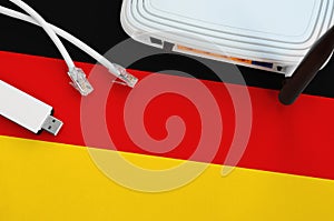 Germany flag depicted on table with internet rj45 cable, wireless usb wifi adapter and router. Internet connection concept