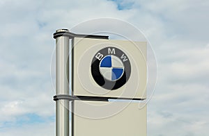 GERMANY, STUTTGART - May 15, 2021: BMW logo on a white banner against a blue cloudy sky