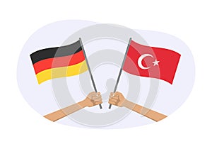 Germany and Turkey flags. Turkish and German national symbols. Hand holding waving flag. Vector illustration