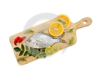 Gerres Fish Gerres Filamentosus , Whipfin silver biddy Fish , Decorated with curry Leaves and Tomato on a Wooden pad,White photo