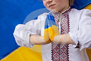 gesture of faith and hope. children\'s hands are painted in yellow and blue