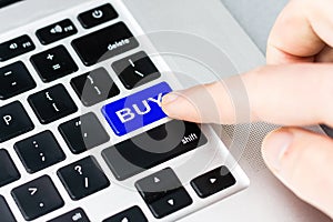 Gesture of finger pressing buy button on a computer keyboard