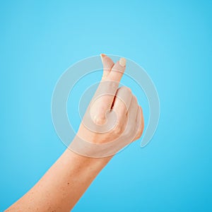 Gesture, hand sign for cash and money closeup on studio blue background for expensive, finance or currency. Person
