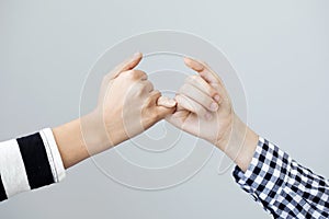 The gesture of the hands mean the promise on grey background