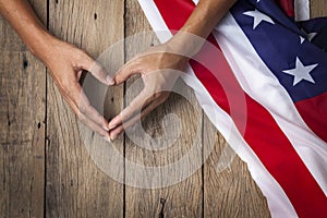 Gesture made by hands showing symbol of heart with american flag