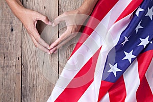 Gesture made by hands showing symbol of heart with american flag