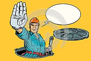 Gesture stop. Plumber in the manhole