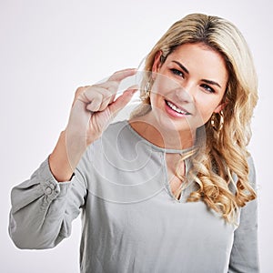 Gesture, young woman and hand doing scale size sign or fingers looking at thumb, standing over isolated white background