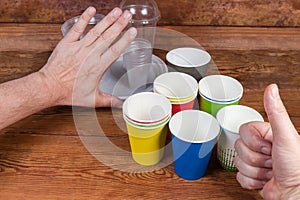 Gestures approving use disposable paper cups and renounce plastic tableware
