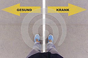 Gesund / Krank, German text for healthy or sick on asphalt ground, feet and shoes on floor photo