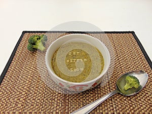 Get better soon written in vegetable soup with spoon