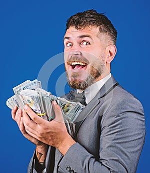 Get cash easy and quickly. Cash transaction business. Man happy winner rich hold pile of dollar banknotes blue