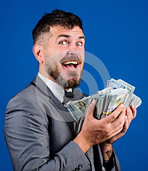 Get cash easy and quickly. Cash transaction business. Man happy winner rich hold pile of dollar banknotes blue