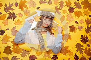 Get comfy wearing this fantastic scarf. Casual fashion trends for fall. Fashion girl look through torn paper with autumn