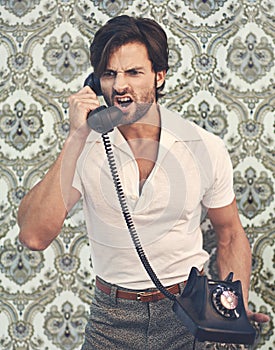 Get it done, NOW. A handsome man in retro 70s clothing shouting at someone on the phone.