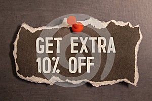 GET EXTRA 10 OFF percent text on a brown tag on a red paper background