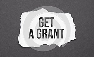 Get a grant sign on the torn paper on the black background