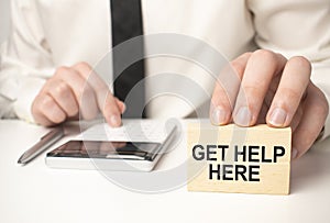 get Help is here and support symbol. Concept words Help is here on wooden blocks on beautiful white table white background