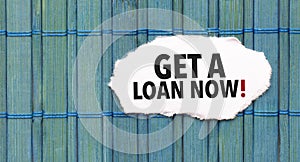 get a loan now word on torn paper with blue wooden background