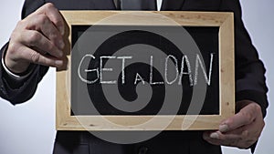 Get a loan written on blackboard, businessman holding sign, business concept