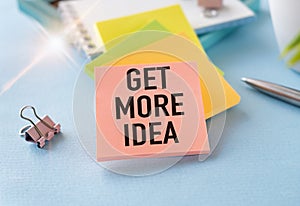 Get More Idea text on the cover of the notebook on the desk. Business concept. Flat lay, top view