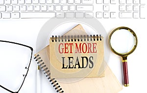 GET MORE LEADS text in the office notebook with keyboard, magnifier and glasses , business concept