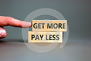 Get more pay less symbol. Concept words Get more pay less on wooden blocks on a beautiful grey table grey background. Businessman