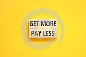 Get more pay less symbol. Concept words Get more pay less on wooden blocks on a beautiful yellow table yellow background. Business