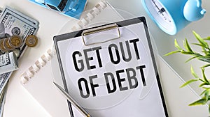 GET OUT OF DEBT text on paper with calculator, notepad, pen with money.