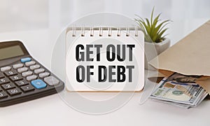 GET OUT OF DEBT text on paper with calculator