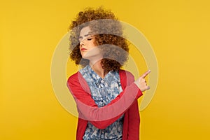 Get out! Portrait of upset vexed woman with curly hair showing exit, demanding to leave her alone