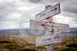 get out of your own way text engraved on old wooden signpost outdoors in nature photo