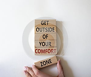 Get outside of your comfort zone symbol. Concept words Get outside of your comfort zone on wooden blocks. Businessman hand.
