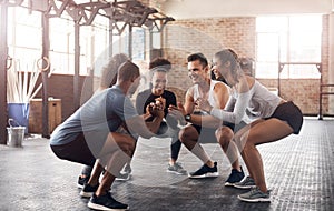 Get ready for strong glutes. a group of young people doing squats together during their workout in a gym.