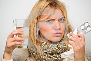 Get rid of flu. Woman wear warm scarf because illness or flu. Girl hold glass water tablets and thermometer nasal drops