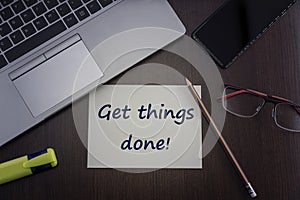Get things done card. Top view of office table desktop background with laptop, phone, glasses and pencil with card with
