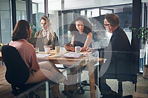 Get together and get a handle on business. a group of businesspeople having a meeting in the boardroom of a modern