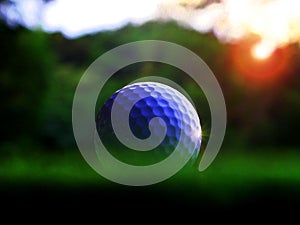 Get up close to the white golf ball of the athlete on a beautiful natural background. On the green lawn