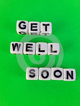 Get well soon words letters on white blocks on a green background