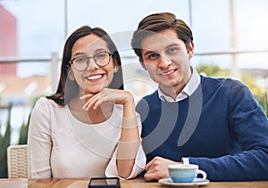 We get the work done as a team. Portrait of two cheerful creative businesspeople having a meeting together while looking