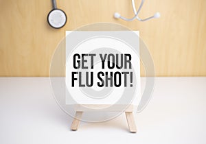 Get Your Flu Shot sign on small wood board rest on the easel with medical stethoscope