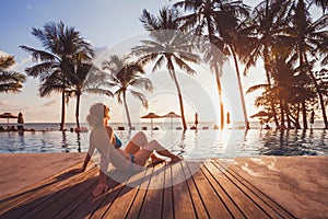 Getaway retreat in luxury beach hotel, luxury travel, woman relaxing near swimming pool photo