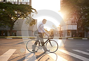 He gets around the green way. a businessman commuting to work with his bicycle.